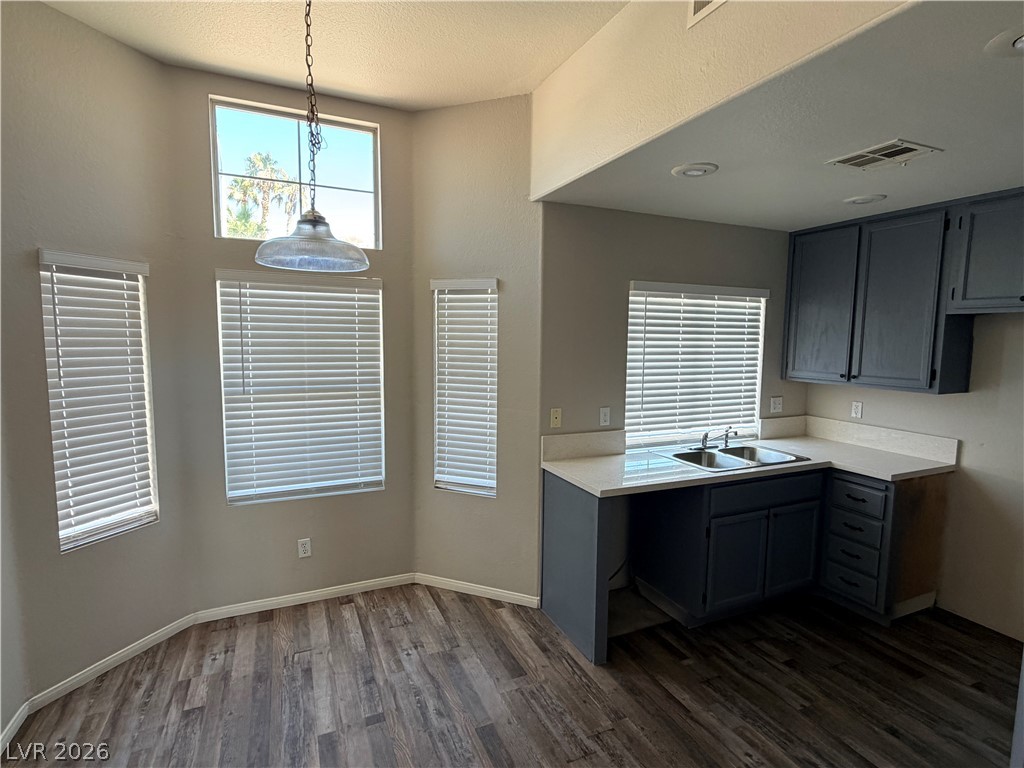 Sunlight streams through multiple windows onto the wood-look flooring of this bright breakfast area.