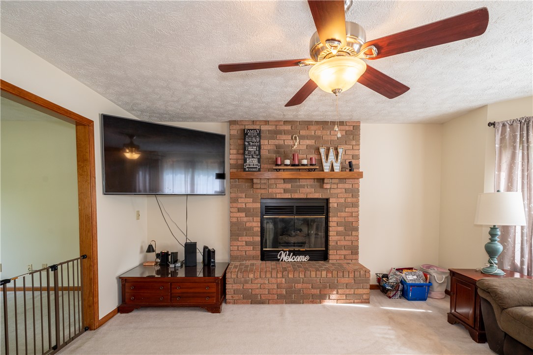 3628 Petre Road Springfield, OH 45502 - Photo 6 of 52 This inviting living room features a classic brick fireplace, creating a warm and welcoming ambiance.
