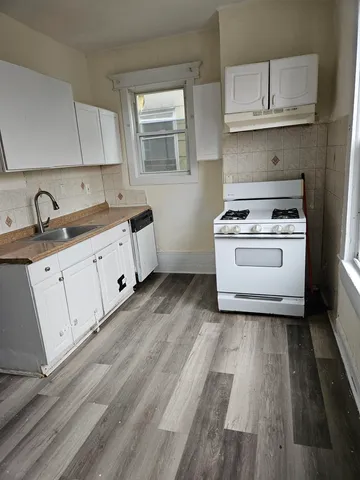 a kitchen with wooden floors and a stove