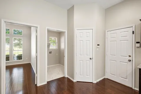 an empty room with wooden floor fireplace and windows