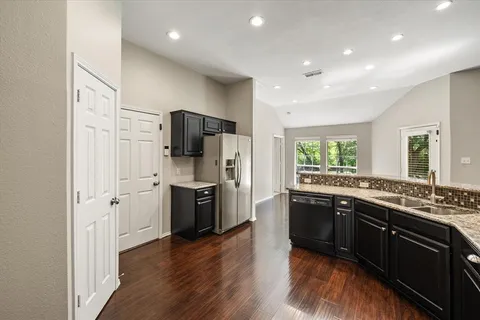 a large kitchen with stainless steel appliances granite countertop a stove and a refrigerator