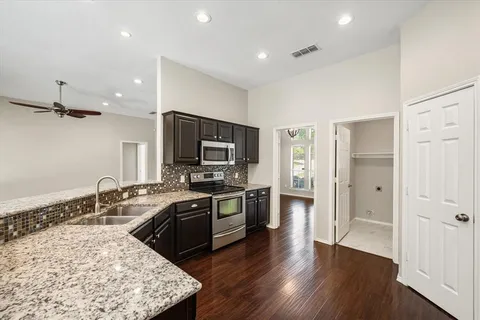 a kitchen with stainless steel appliances granite countertop a sink stove and refrigerator