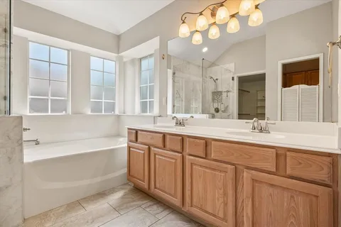 a bathroom with a large tub sink and mirror