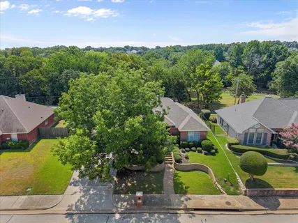 an aerial view of a house with garden space and street view