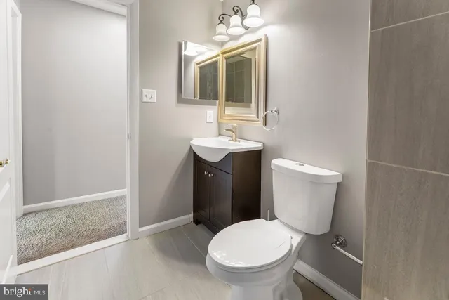a bathroom with a toilet sink and mirror