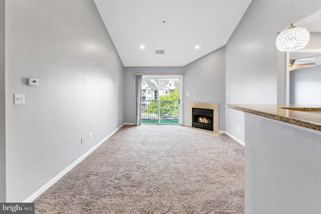 en empty room with windows and fireplace