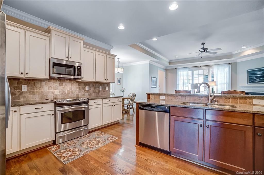 694 Revival Row Fort Mill, SC 29708 - Photo 15 of 46 a kitchen with granite countertop wooden cabinets and stainless steel appliances