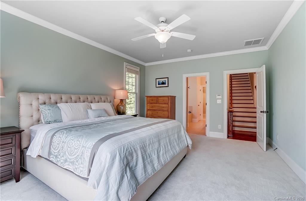 694 Revival Row Fort Mill, SC 29708 - Photo 27 of 46 a spacious bedroom with a bed and a chandelier