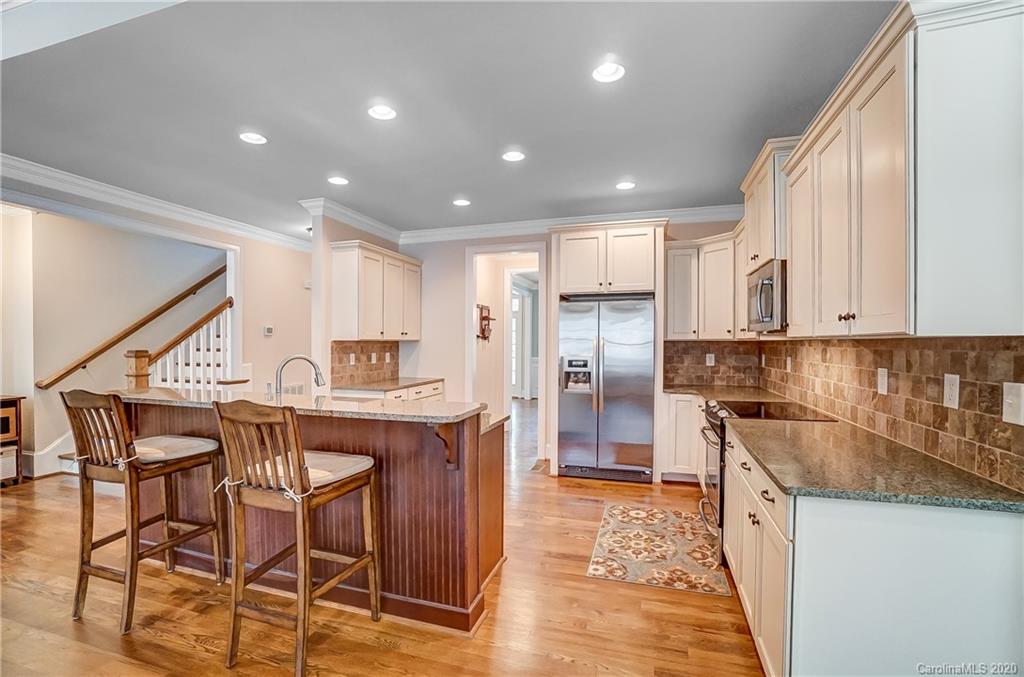 694 Revival Row Fort Mill, SC 29708 - Photo 10 of 46 a kitchen with stainless steel appliances granite countertop a table chairs sink and cabinets