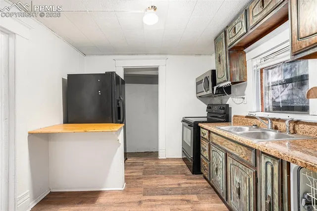 a kitchen with stainless steel appliances granite countertop a sink and a refrigerator