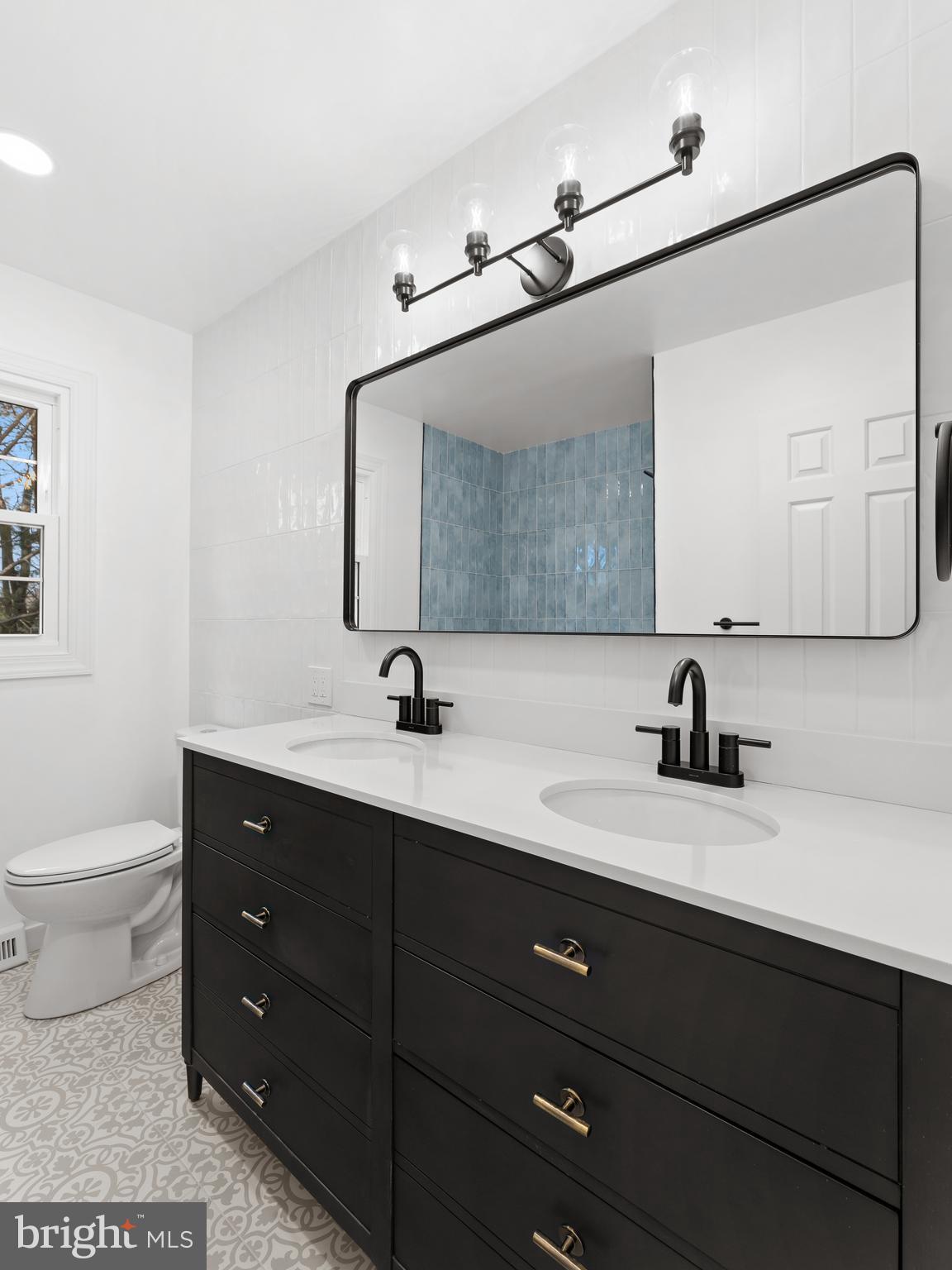 972 Roeloffs Road Yardley, PA 19067 - Photo 40 of 64 a bathroom with a toilet a double vanity sink and mirror
