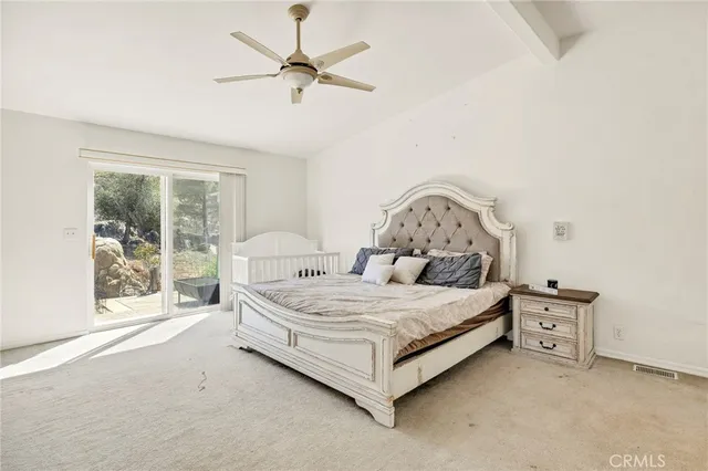 a spacious bedroom with a bed table and window