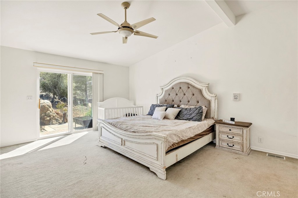 35125 Stirrup Road Temecula, CA 92592 - Photo 18 of 51 a spacious bedroom with a bed table and window
