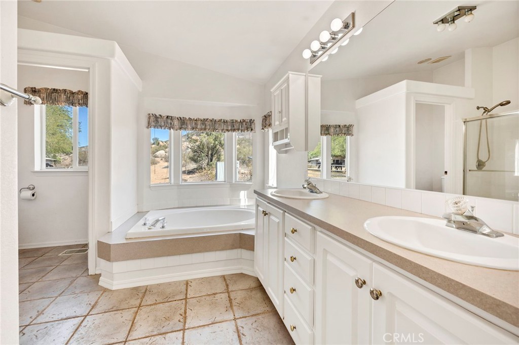 35125 Stirrup Road Temecula, CA 92592 - Photo 23 of 51 a spacious bathroom with a tub sink and mirror