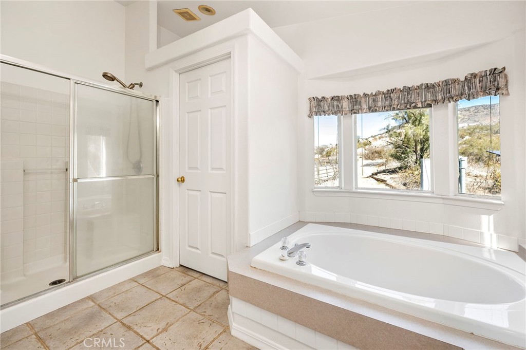 35125 Stirrup Road Temecula, CA 92592 - Photo 24 of 51 a bathroom with a bathtub and a shower