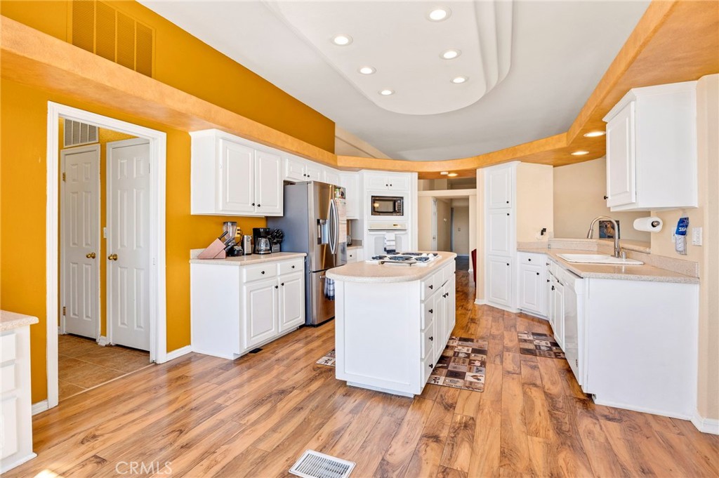 35125 Stirrup Road Temecula, CA 92592 - Photo 10 of 51 a large kitchen with a lot of counter space and a wooden floor