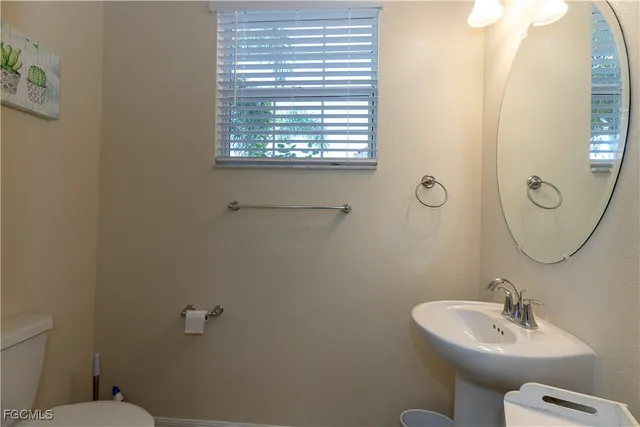 a bathroom with a sink mirror and toilet
