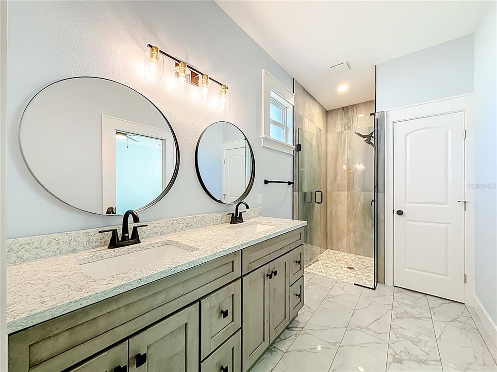 12847 Southwest 73rd Street Ocala, FL 34473 - Photo 18 of 28 a bathroom with a double vanity sink mirror and shower