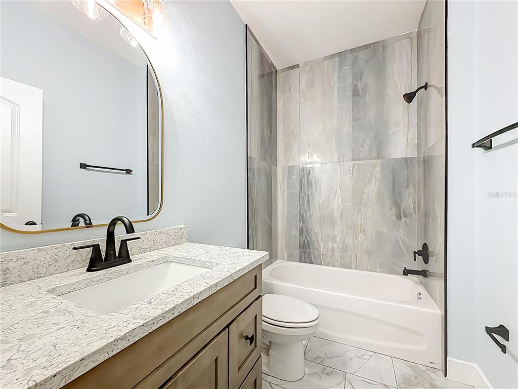 12847 Southwest 73rd Street Ocala, FL 34473 - Photo 19 of 28 a bathroom with a granite countertop sink toilet and shower