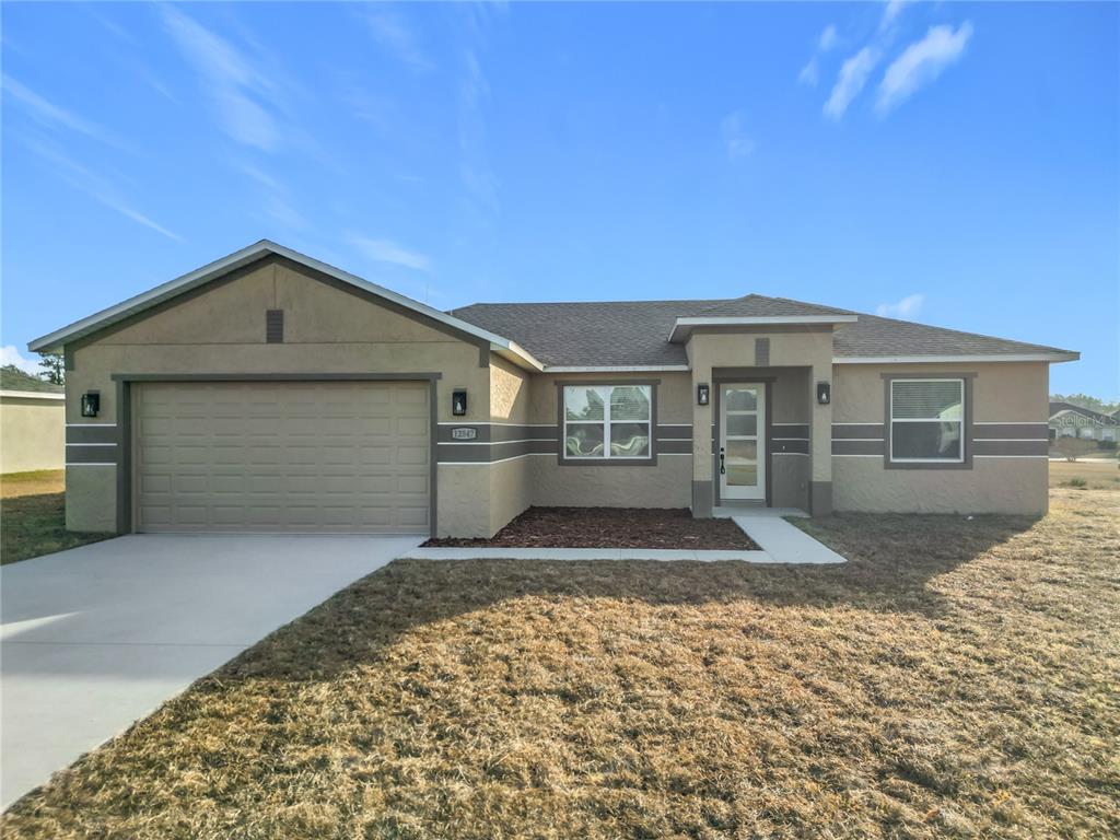 12847 Southwest 73rd Street Ocala, FL 34473 - Photo 4 of 28 a front view of a house with a yard