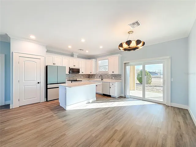 a kitchen with a refrigerator and a stove top oven
