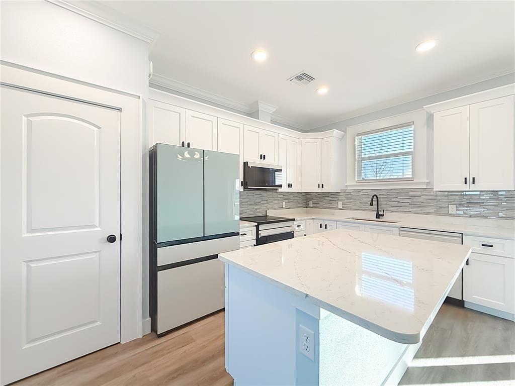 12847 Southwest 73rd Street Ocala, FL 34473 - Photo 10 of 28 a kitchen with a refrigerator a sink and cabinets