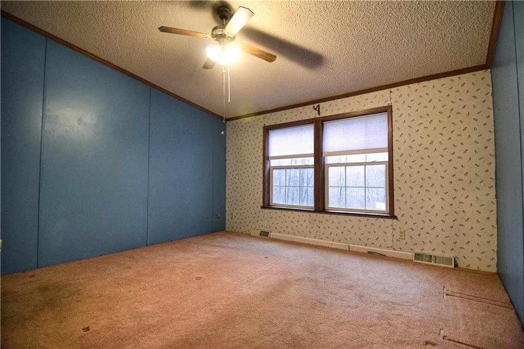 3172 Old Rte 8 Polk, PA 16342 - Photo 11 of 18 an empty room with chandelier fan and windows