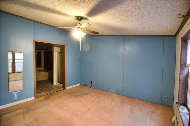 a view of a livingroom with a chandelier fan and a bathroom