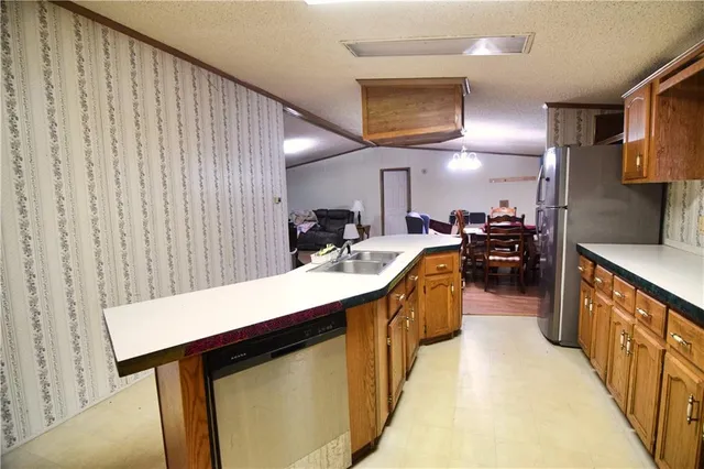 a kitchen with stainless steel appliances granite countertop a sink a stove top oven a counter space and cabinets