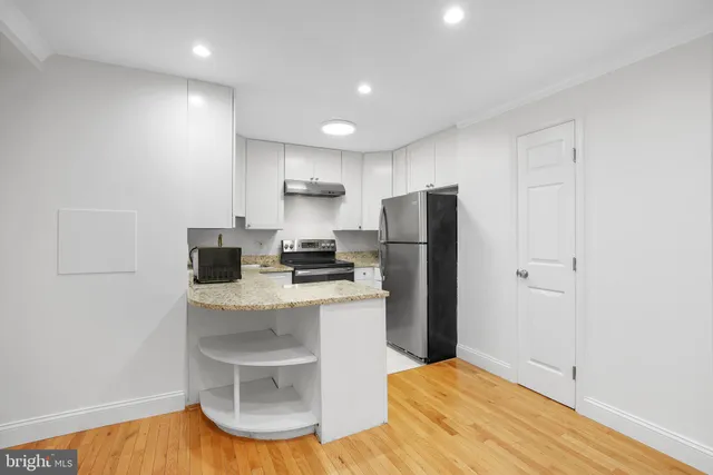 a kitchen with stainless steel appliances a refrigerator and a stove top oven
