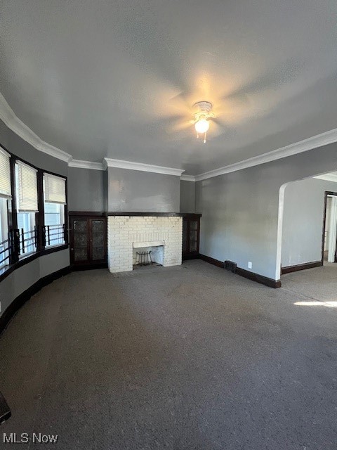 1842 Colonnade Road Cleveland, OH 44112 - Photo 11 of 47 Unfurnished living room featuring ceiling fan, carpet floors, a fireplace, and crown molding
