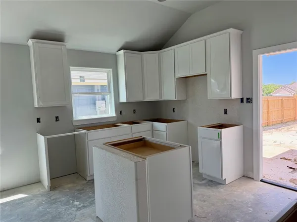 a kitchen that has a sink and a stove with white countertops