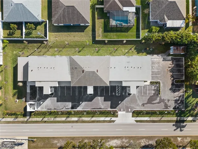 front view of house with a yard and large trees
