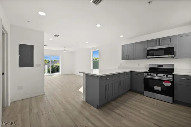 a large kitchen with stainless steel appliances granite countertop a stove a sink and a microwave