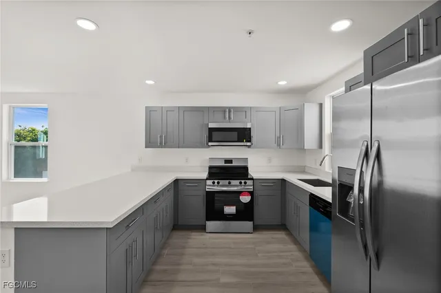 a kitchen with stainless steel appliances granite countertop a refrigerator a sink and a stove