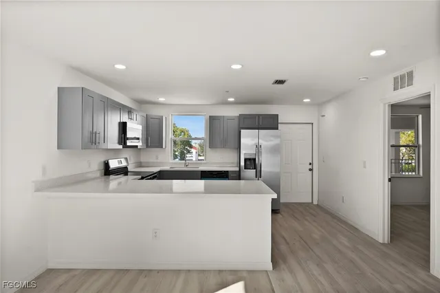 a large white kitchen with a large window
