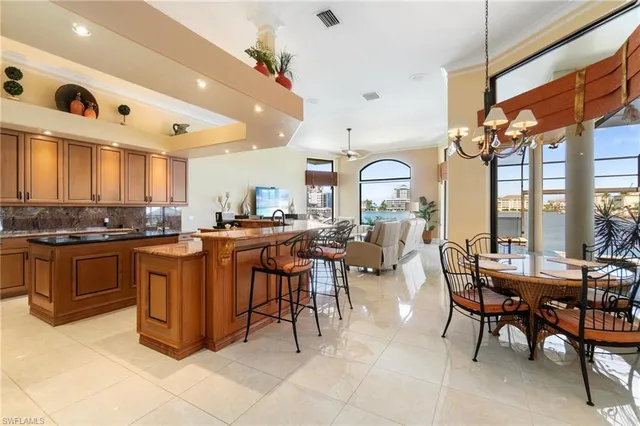 a dining room with wooden floor a chandelier a glass table and chairs