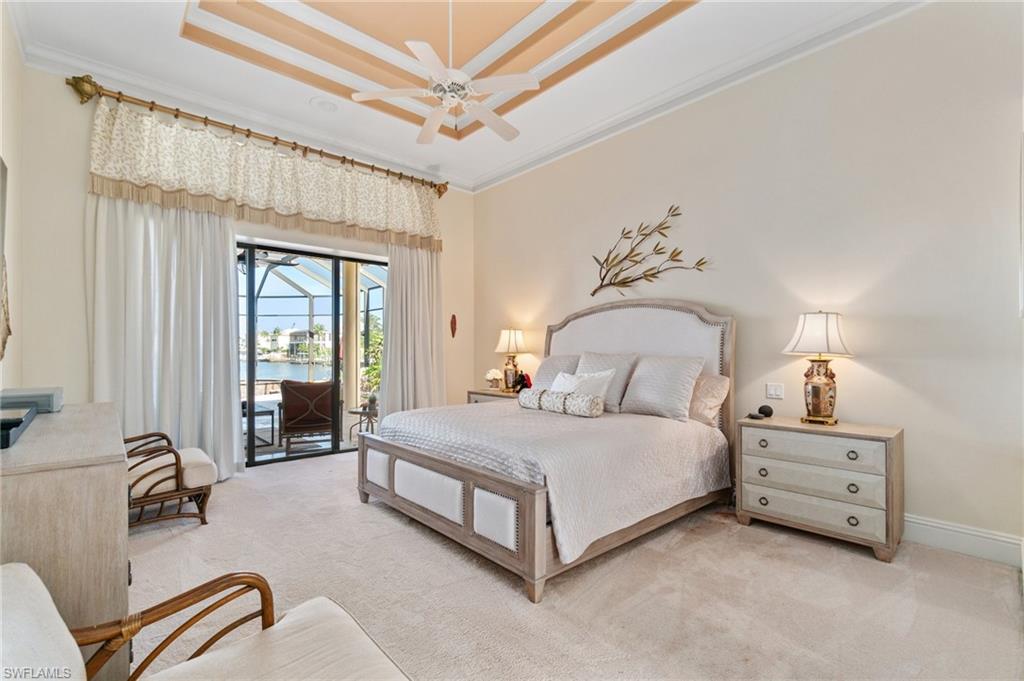 431 Palm Court Naples, FL 34108 - Photo 25 of 50 a spacious bedroom with a bed a couch and large windows