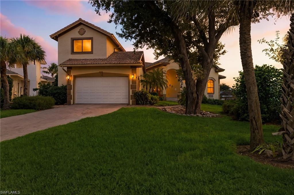 431 Palm Court Naples, FL 34108 - Photo 3 of 50 a front view of a house with a yard and garage