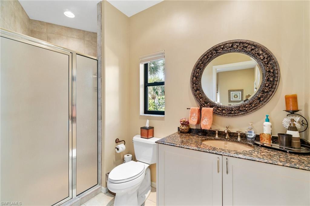 431 Palm Court Naples, FL 34108 - Photo 31 of 50 a bathroom with a granite countertop toilet a sink and a mirror