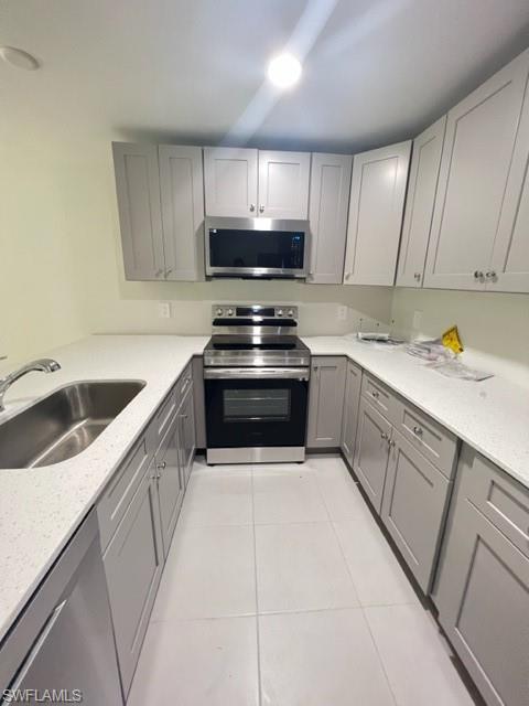 4414 Douglas Lane Lehigh Acres, FL 33973 - Photo 13 of 15 Kitchen featuring gray cabinetry, electric stove, light stone countertops, dishwasher, and light tile patterned flooring
