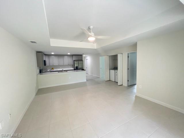 4414 Douglas Lane Lehigh Acres, FL 33973 - Photo 15 of 15 Unfurnished living room featuring a raised ceiling, a ceiling fan, and light tile patterned floors
