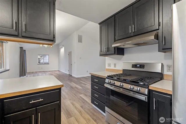 a kitchen with wooden cabinets and a stove top oven