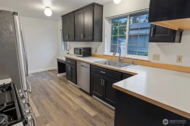 a kitchen with stainless steel appliances granite countertop a sink a stove and a refrigerator