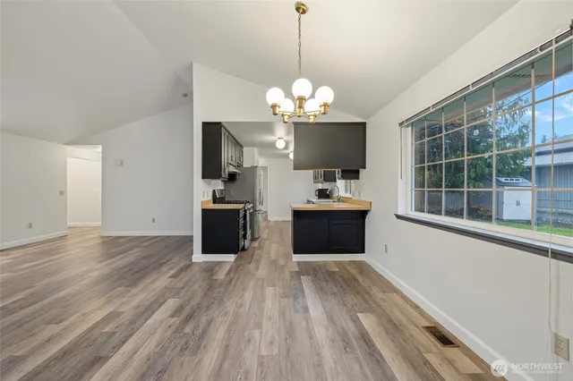 a view of a kitchen with wooden floor and windows