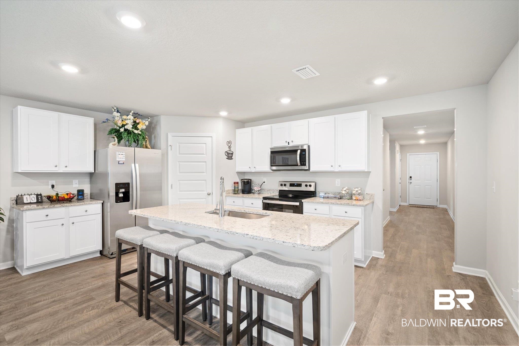 446 Paget Drive East Mobile, AL 36608 - Photo 3 of 20 Kitchen with a kitchen island with sink, white cabinets, sink, appliances with stainless steel finishes, and light hardwood / wood-style floors