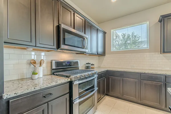 a kitchen with stainless steel appliances granite countertop white cabinets stove a sink and dishwasher