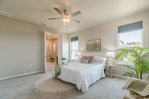a spacious bedroom with a bed a chandelier and a window