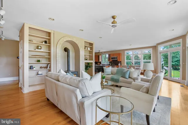 a living room with furniture ceiling fan and a large window