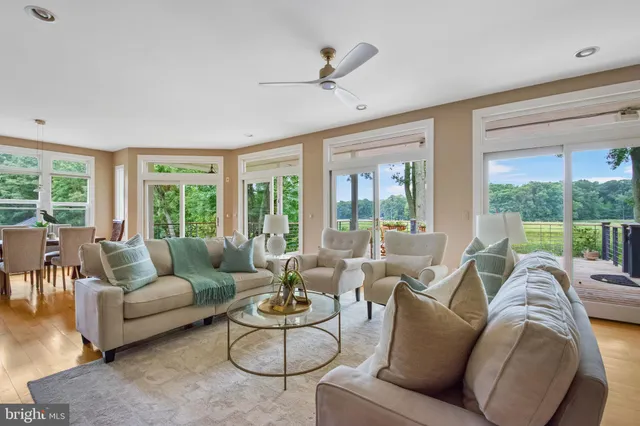 a view of a lake with couches in wooden deck and a lake view